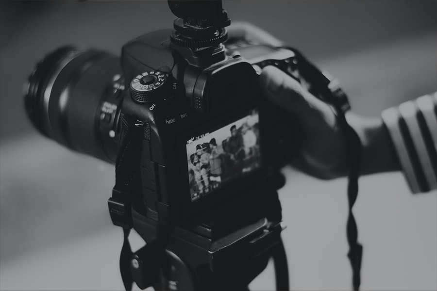 Photographer taking a picture with a digital camera on a tripod