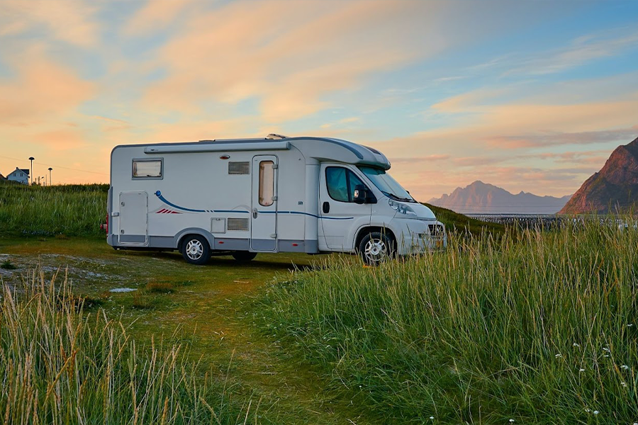 White RV on green grass field during daytime