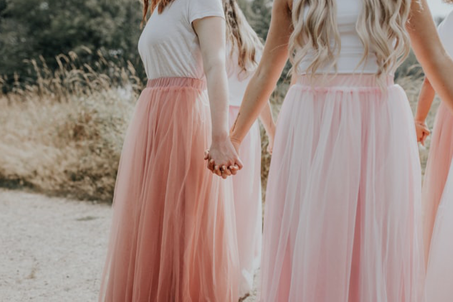 Women wearing long skirts and white tops