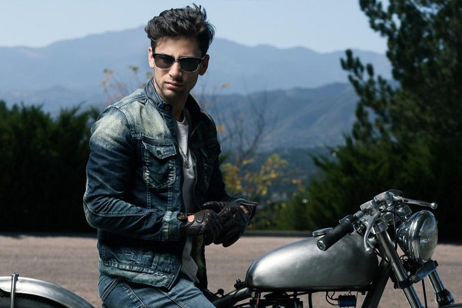 Young man wearing a tobacco denim sitting on a bike