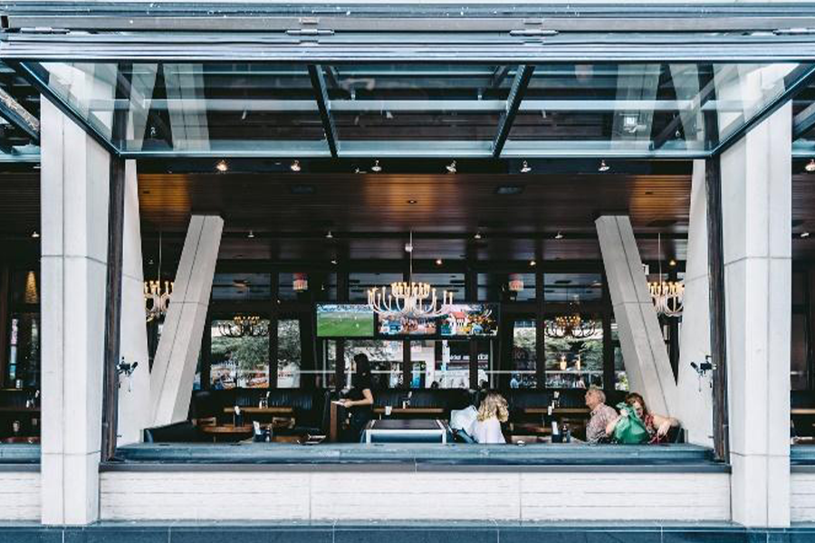 Restaurant with open black vertical folding windows