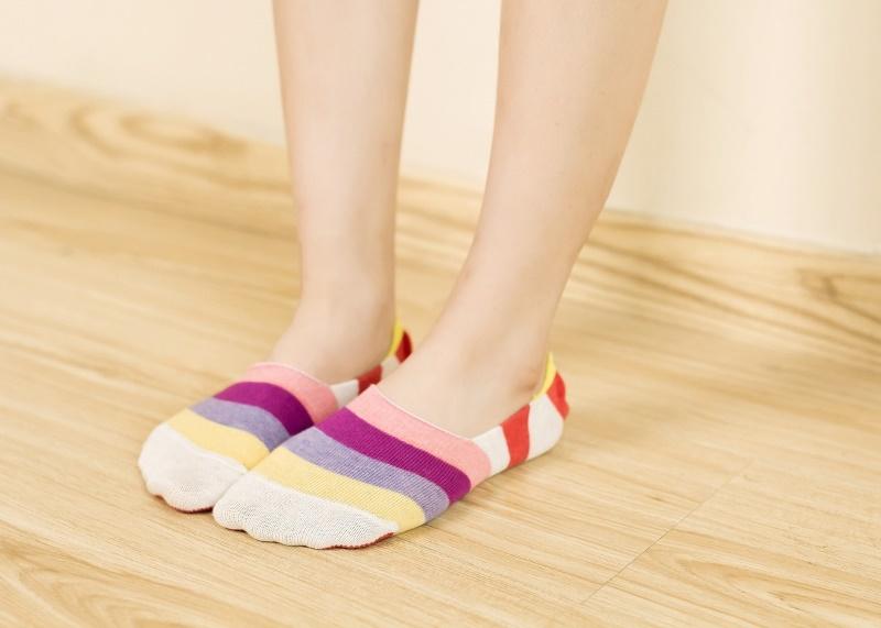 Feet wearing colorful striped no show socks