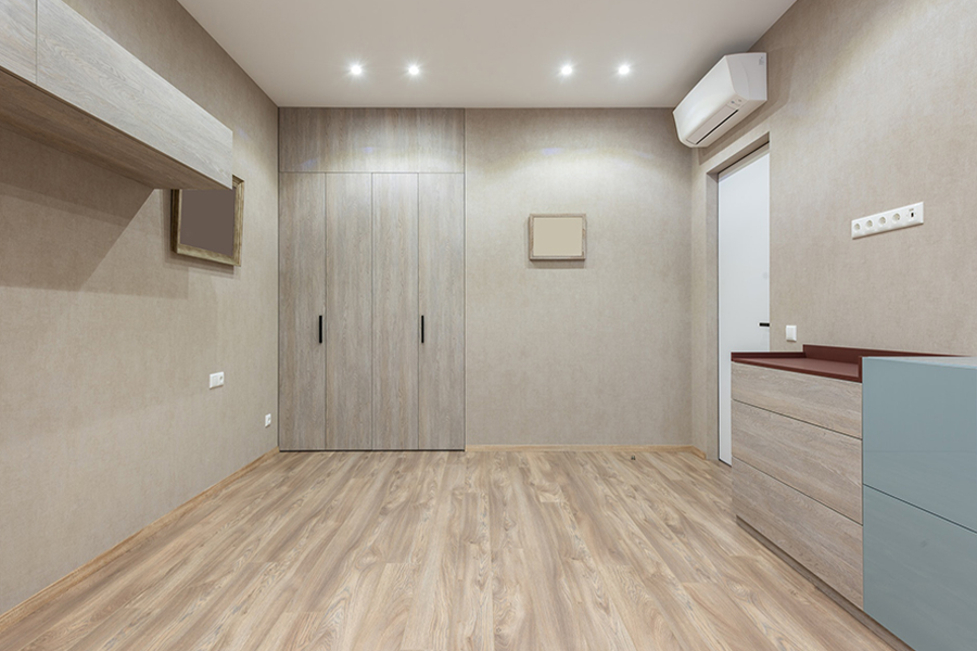 A gray ceiling to floor wardrobe in a spacious bedroom