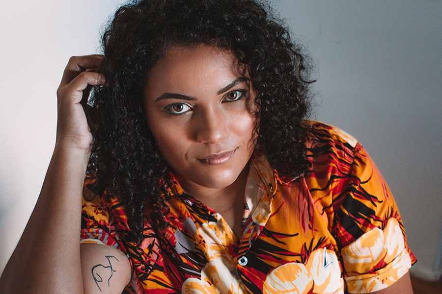 Black lady in an orange Hawaiian-print top