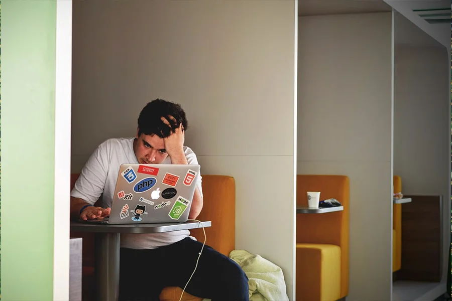 Employee looking stressed over work in a cafeteria