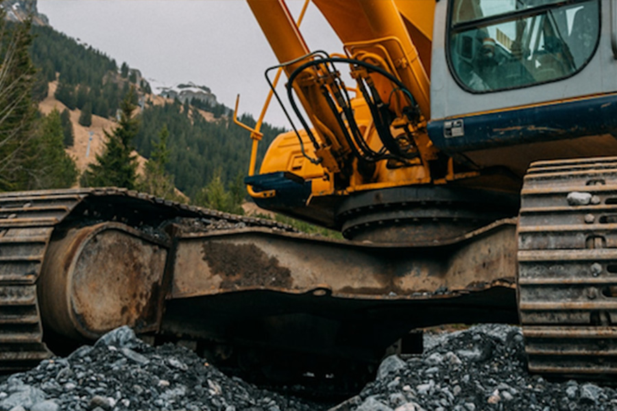 Excavator Tracks And Undercarriage On Hard Gravel