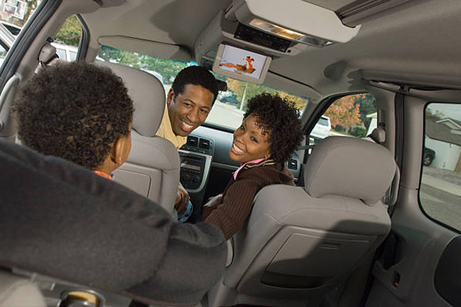 family in a van with a dvd player in roof