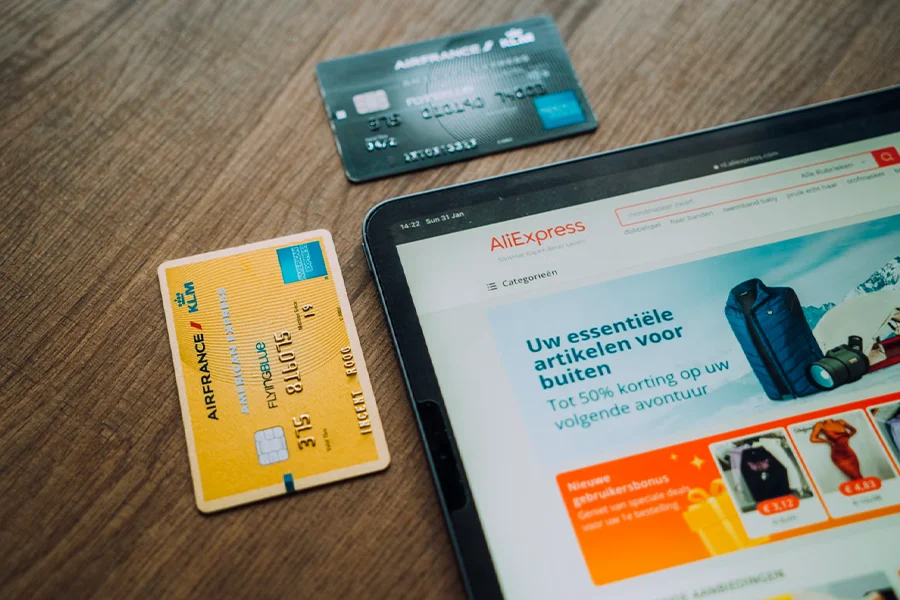 Tablet showing AliExpress e-commerce marketplace and a pair of cards