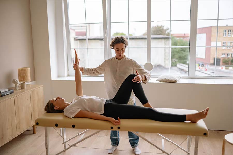 Therapist treating a client on stationary bed during session