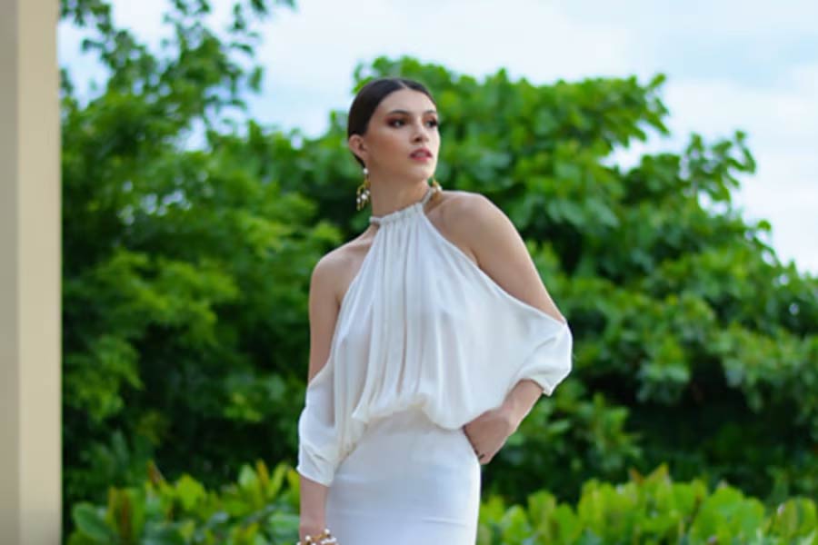 Woman wearing white halter neck cold shoulder dress