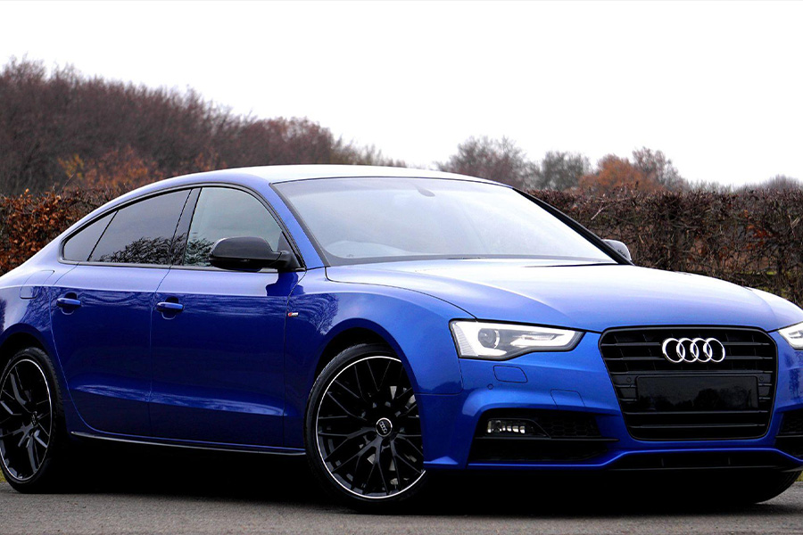 A blue Audi Sedan near forest