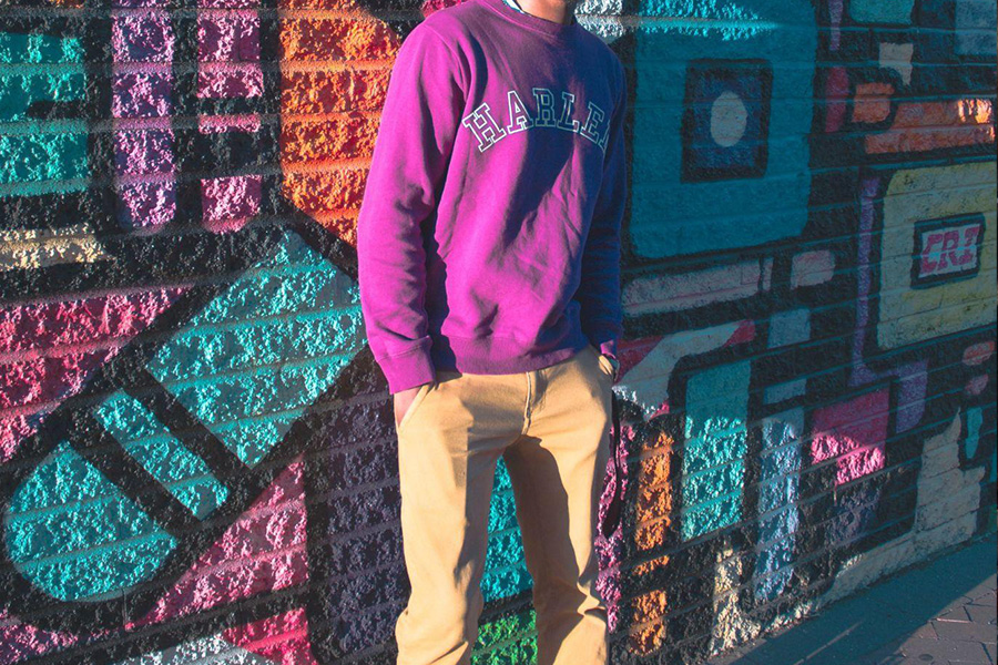 A man wearing a purple hoodie and brown pants