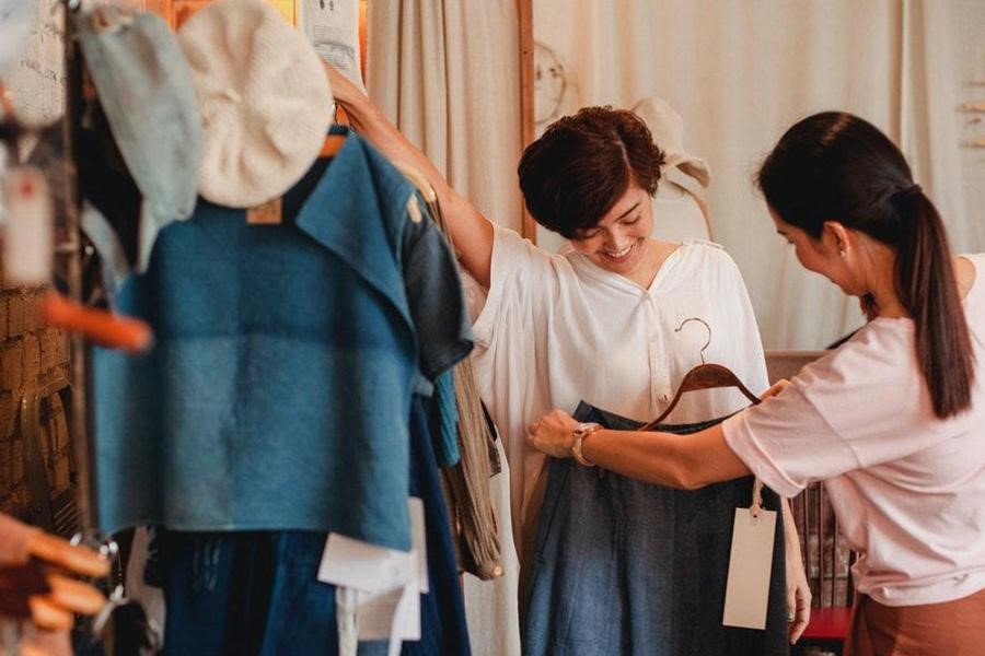 Clothing business owner giving a model clothes to test