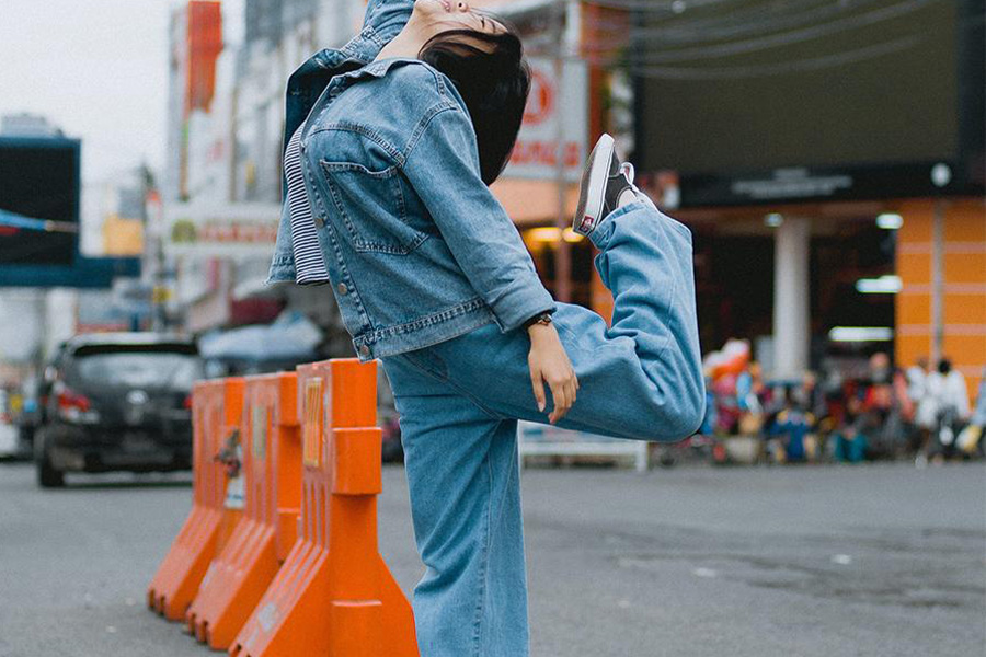 Lady rocking denim jacket and loose pants outdoors