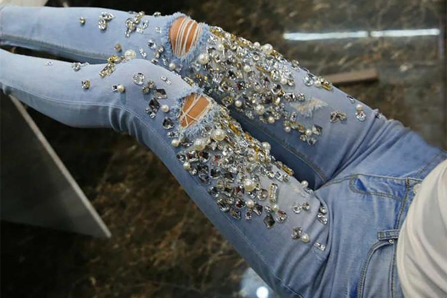 Lady rocking white top over pencil jeans with stone embellishments