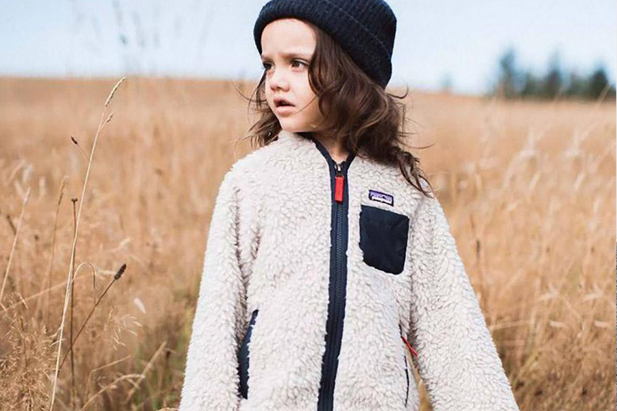 Little girl wearing a white fleece jacket and a hat