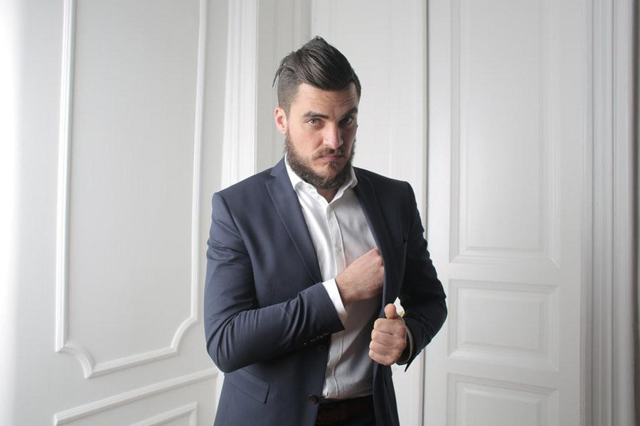 Man rocking blue blazers beside white wooden door