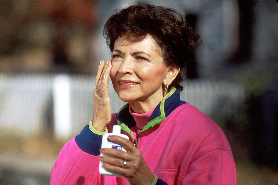 Person applying sunscreen to protect her skin