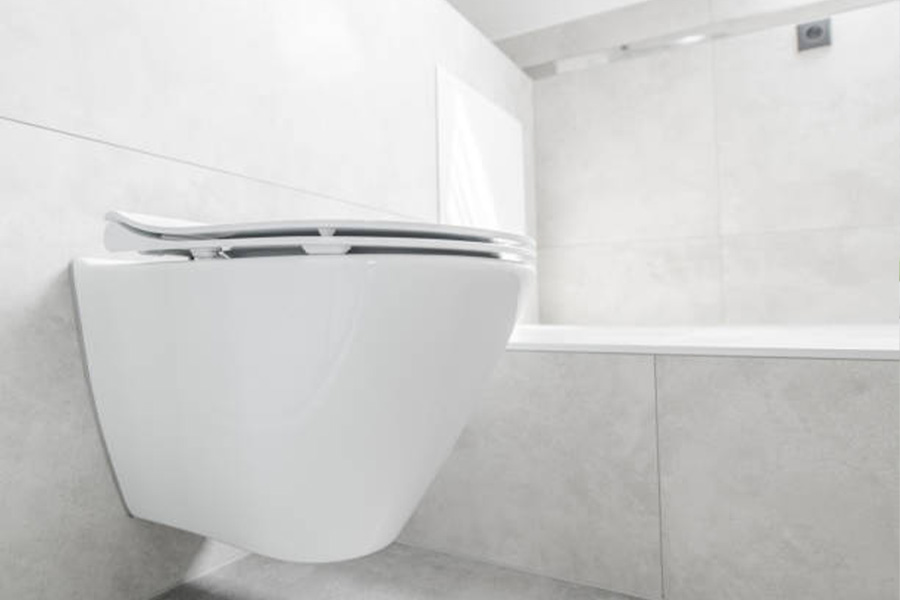 White wall-hanging toilet in a marble-tiled bathroom