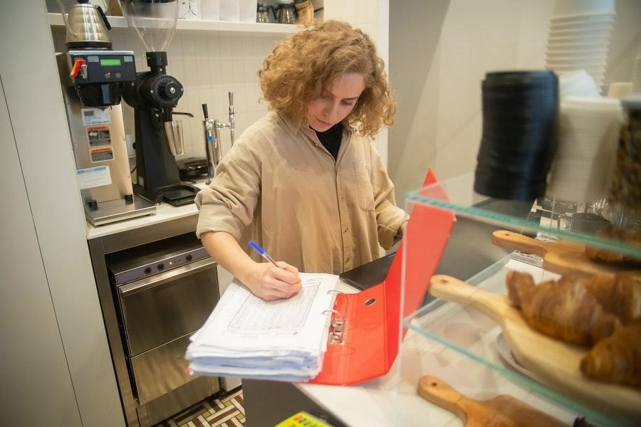 Woman in brown top checking inventory records