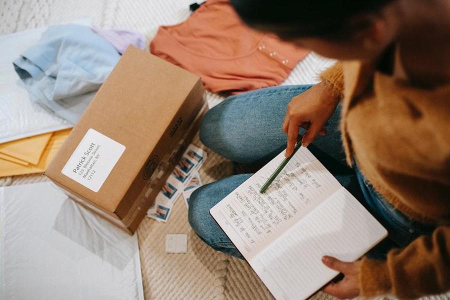 Woman writing down plans and goals on a book