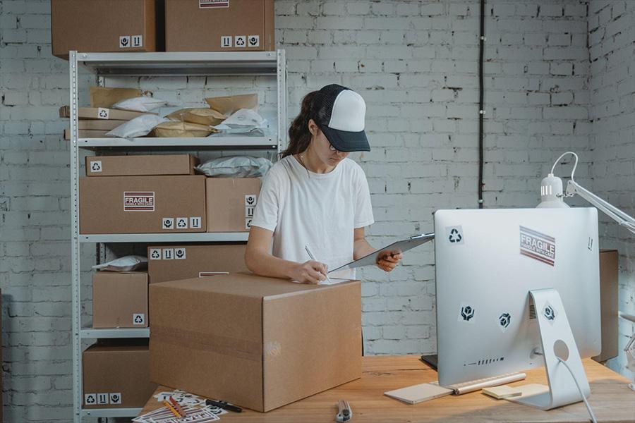 a lady looking a clipboard at a distribution center