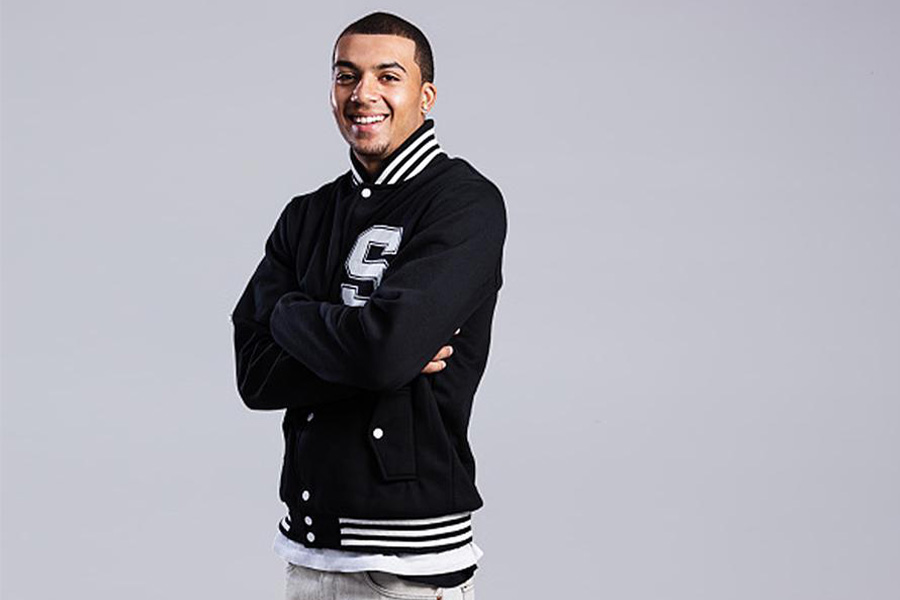 A man wearing a monochrome letterman jacket