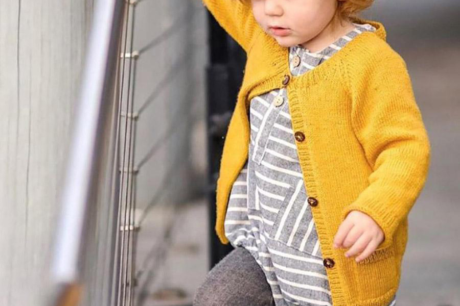 Boy wearing a burnt-yellow cardigan