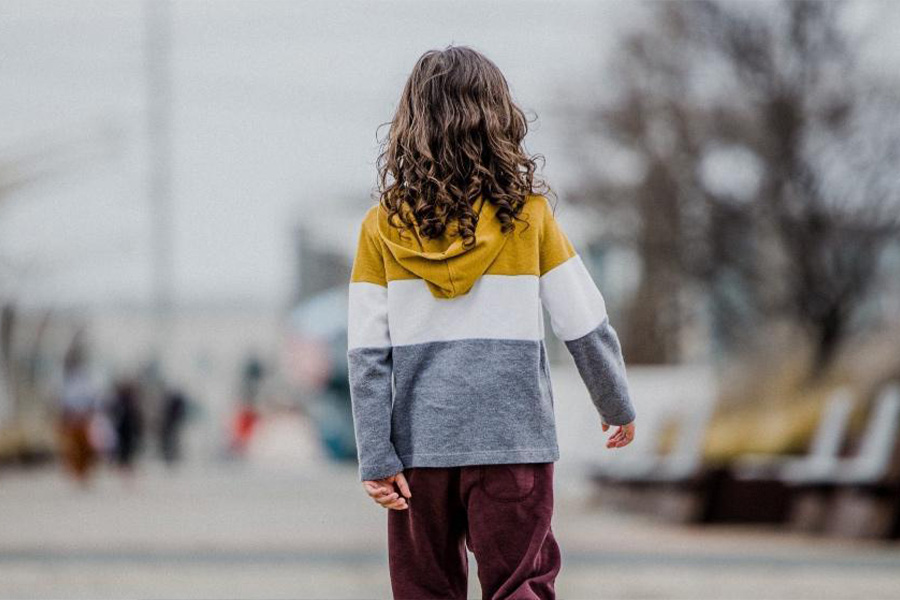 Girl in a multicolored sweatshirt and brown pants