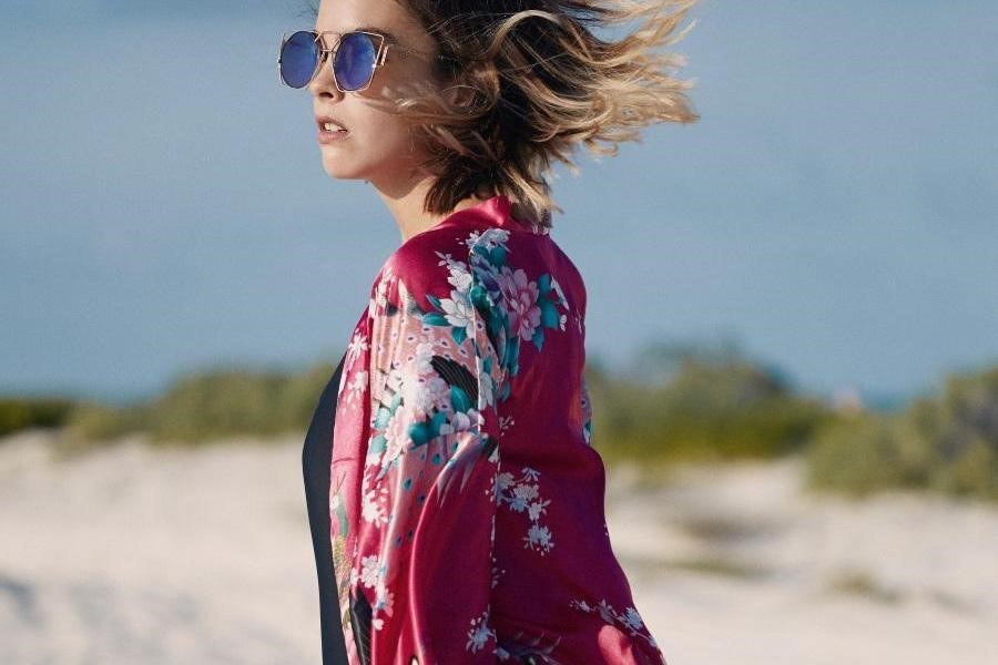 Lady wearing a bright red shirt with an intricate floral pattern