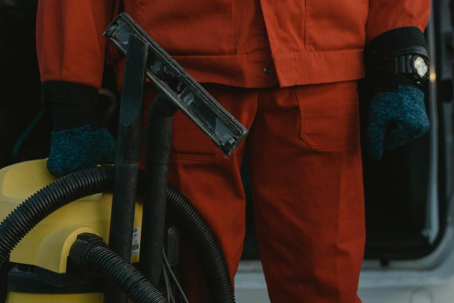 A man holding a large vacuum cleaner