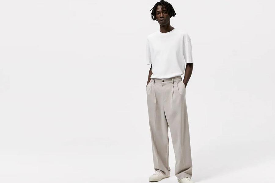 Model with dreadlocks rocking a gray wide-leg pant