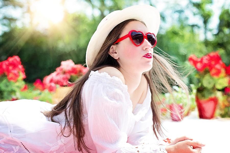 Teen girl with red sunglasses and white sheer dress