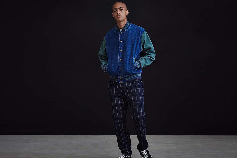 Young male model rocking denim letterman jacket over plaid pants