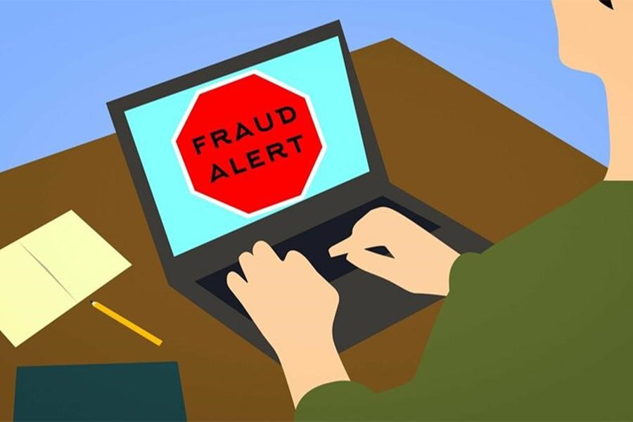 A fraud alert notification displayed on a laptop