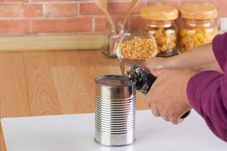 A manual can opener on a white background