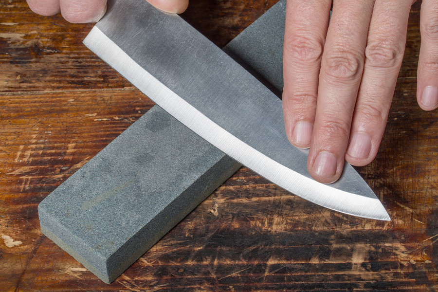 A woman sharpening a kitchen knife