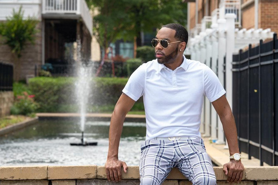 Man sitting on a ledge with white polo shirt