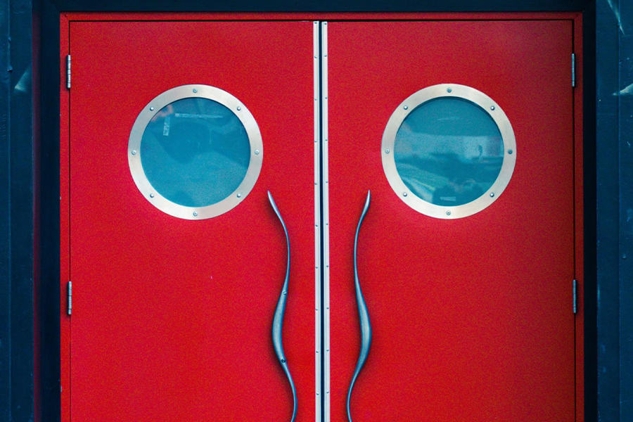 A red door with unusual metal handles