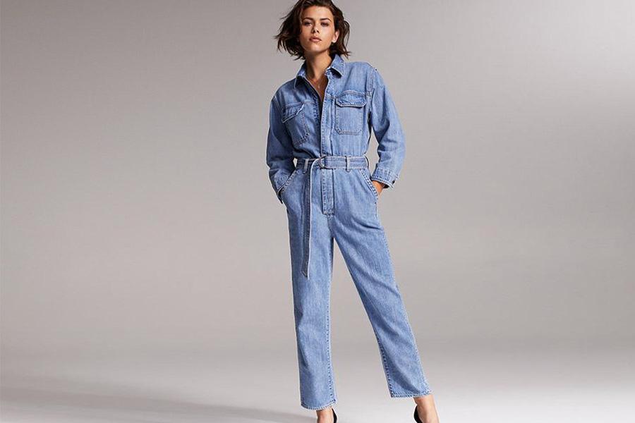 Stylish female model wearing a light blue denim boilersuit