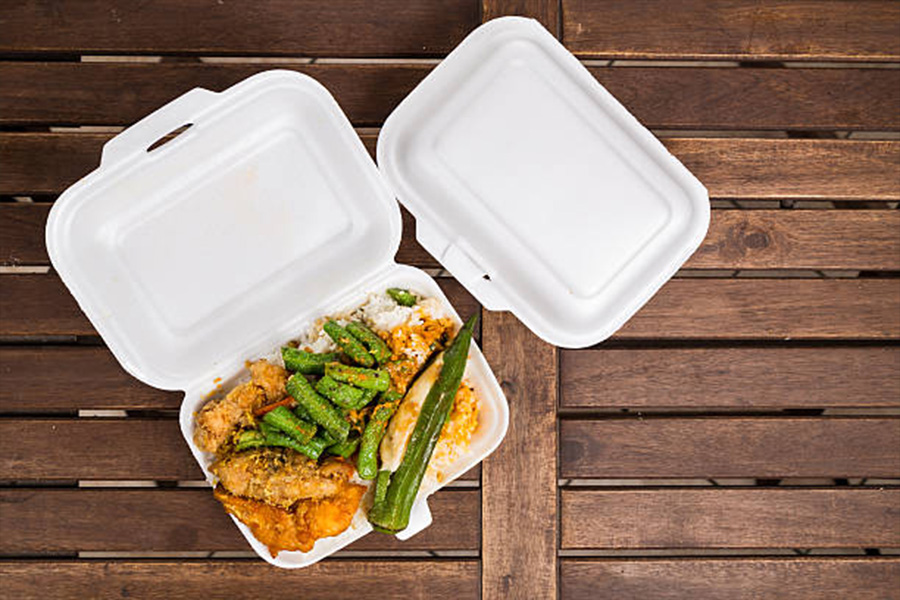 Two biodegradable food containers set on a wooden table