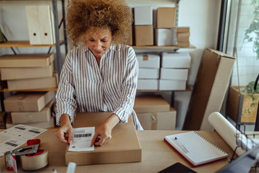 Woman attaching shipping label to a box