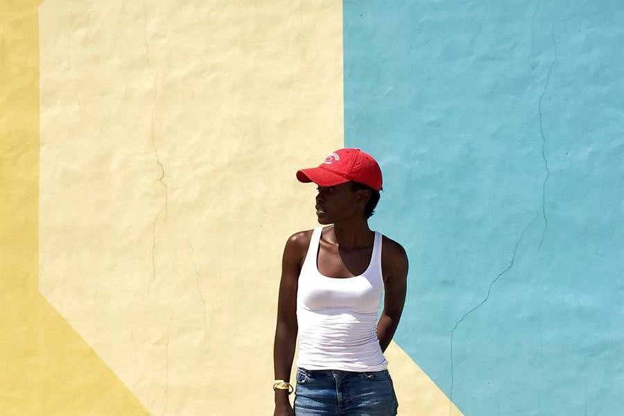 Woman wearing a white tank top and a red hat