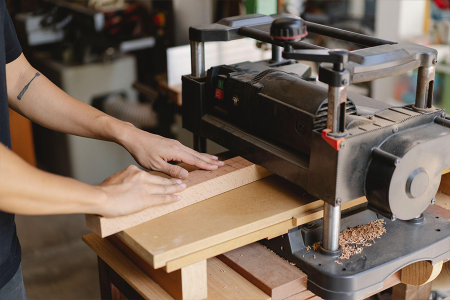 Woodworker operating a planer machine