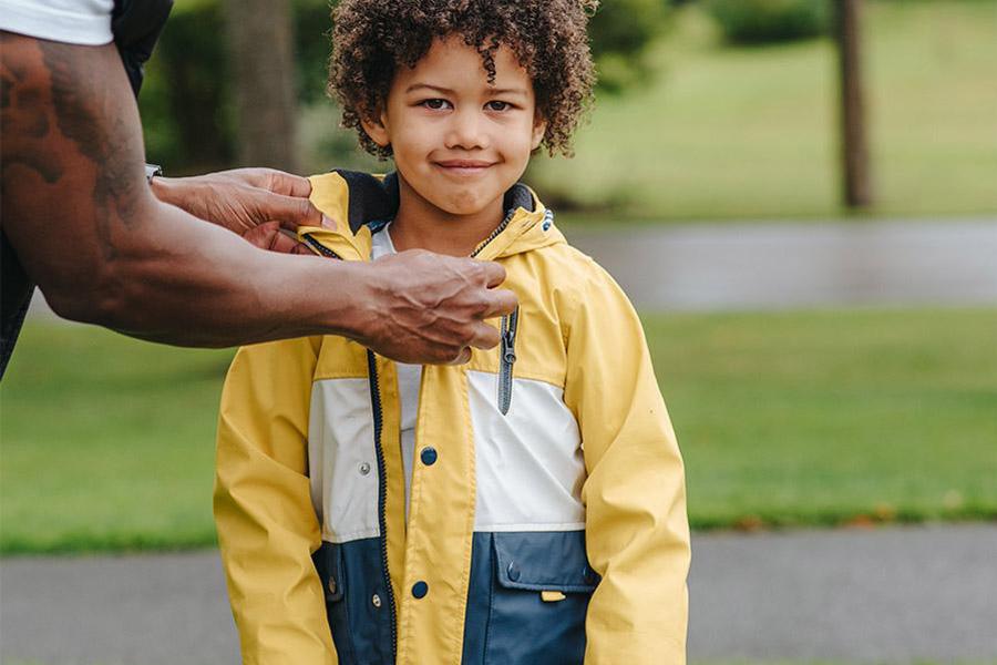 Young boy wearing a yellow and blue utility jacket