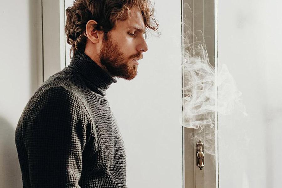 Young man rocking a black roll-neck sweater