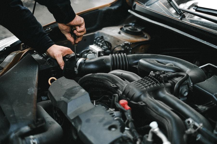 A man checking engine with tools