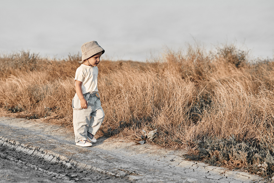 Child walking down a road in relaxed trousers