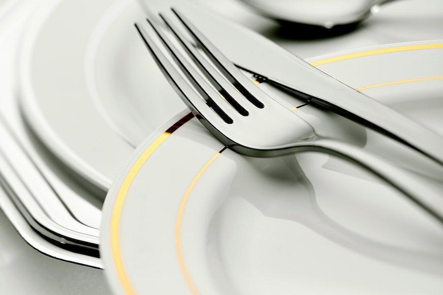 Close-up shot of bone china dinnerware with cutleries