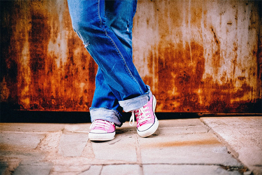 Closeup shot of woman crossing legs in relaxed carpenter jeans